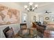 The dining room has hardwood floors and a glass dining table with seating and chandelier at 1115 Wake Forest Rd # B, Raleigh, NC 27604