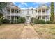Charming brick townhouse with dual covered front porches and a welcoming walkway to the front door at 1115 Wake Forest Rd # B, Raleigh, NC 27604