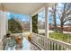 Inviting covered porch with a glass-topped table and comfortable seating, perfect for relaxing outdoors at 1115 Wake Forest Rd # B, Raleigh, NC 27604