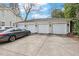 Four-car garage with white doors, black lighting fixtures, driveway, and an adjacent parked vehicle at 1115 Wake Forest Rd # B, Raleigh, NC 27604