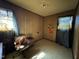 Small, basic bedroom with wood paneling, carpeted floors, and natural light from a window at 113 Smith St, Four Oaks, NC 27524