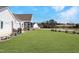 Spacious backyard with a covered porch, open patio, lush green grass, and mature trees at 118 Riverwood Dr, Fuquay Varina, NC 27526