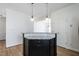 Stylish black kitchen island with granite countertop, cabinet storage, and pendant lighting at 118 Riverwood Dr, Fuquay Varina, NC 27526