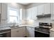 Modern kitchen featuring white cabinets, stainless steel appliances, granite counters, and subway tile backsplash at 118 Riverwood Dr, Fuquay Varina, NC 27526