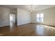 Spacious living room with hardwood floors, a modern chandelier, and open layout at 118 Riverwood Dr, Fuquay Varina, NC 27526