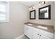 Bathroom featuring a double sink vanity with two mirrors and white cabinetry at 120 W College St, Oxford, NC 27565
