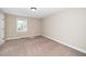 Neutral bedroom featuring a window, a light, and tan carpet at 120 W College St, Oxford, NC 27565