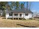 Charming home featuring a cozy front porch, dark shutters, and a well-maintained yard at 120 W College St, Oxford, NC 27565