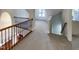Inviting hallway with decorative railing, carpeted floor and natural light creates a seamless transition at 138 Parkdale Ln, Clayton, NC 27520