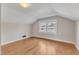 A bedroom with wood floors is lit by a central light and window at 152 E Tryon St, Hillsborough, NC 27278