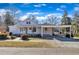 Charming single-story home with a covered porch and carport, set against a bright blue sky at 152 E Tryon St, Hillsborough, NC 27278