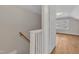 A hallway with a wooden banister and an open door showcases the hardwood floor at 152 E Tryon St, Hillsborough, NC 27278