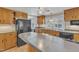 Spacious kitchen with wood cabinetry, black appliances, and a convenient breakfast bar at 152 E Tryon St, Hillsborough, NC 27278