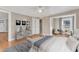 Bright main bedroom with neutral tones, light wood flooring, ceiling fan, and a seating area at 152 E Tryon St, Hillsborough, NC 27278