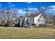View of the rear of the house with a well-maintained lawn and mature trees at 152 E Tryon St, Hillsborough, NC 27278