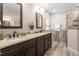 Spacious bathroom featuring a double sink vanity with sleek dark wood cabinets and a tiled walk-in shower at 1701 Legendary Ln, Morrisville, NC 27560