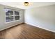 This bedroom features a hardwood floor, a window with natural light, and neutral paint colors at 1756 Main Divide Dr, Wake Forest, NC 27587