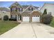 Charming two-story home featuring a stone facade, two-car garage, and well-manicured lawn at 1756 Main Divide Dr, Wake Forest, NC 27587