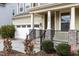 A two story house with a covered porch, stone accents, and a two car garage at 1800 Bodwin Ln, Apex, NC 27502