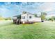 Spacious backyard view of this charming, white, single-story home with brick foundation at 201 Colonial Ave, Goldston, NC 27252