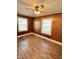 Bedroom with paneled walls, wood-look flooring, and natural light from two windows at 201 Colonial Ave, Goldston, NC 27252
