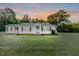 Charming single-story home with manicured front yard and inviting entrance at sunset at 201 Colonial Ave, Goldston, NC 27252