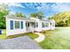 Quaint home with walkway, landscaping, and blue shutters on a beautiful sunny day at 201 Colonial Ave, Goldston, NC 27252