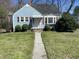 Charming blue home featuring a well-manicured lawn and inviting front entrance at 214 Grace St, Oxford, NC 27565