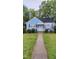 Charming blue cottage-style home featuring a walkway, well-manicured lawn, and classic architectural details at 214 Grace St, Oxford, NC 27565
