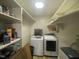 Bright laundry room featuring modern washer and dryer units, along with ample shelving at 214 Grace St, Oxford, NC 27565