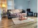 A cozy living room with hardwood floors, a plush gray sofa, and a soft, inviting rug at 214 Grace St, Oxford, NC 27565