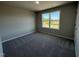 An empty bedroom featuring neutral walls, plush carpet, and a window at 22 Wynd Crest Way, Benson, NC 27504
