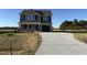 Two-story home with gray siding, a dark roof, and a paved driveway leading to an attached garage at 22 Wynd Crest Way, Benson, NC 27504