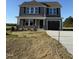 New construction gray home with a two car garage, covered porch and professionally staged bare front lawn at 22 Wynd Crest Way, Benson, NC 27504