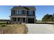 Charming two-story home featuring gray siding, black shutters, a covered porch, and a two-car garage at 22 Wynd Crest Way, Benson, NC 27504