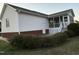 Home's backyard featuring white siding, brick foundation, screened porch, and well-maintained landscaping at 254 Pedernales Dr, Smithfield, NC 27577