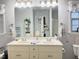 Bathroom with double sinks, large mirror, white cabinets, and decorative blue and white accents at 254 Pedernales Dr, Smithfield, NC 27577