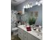 This bathroom features a double vanity with plants, a floral shower curtain, and framed art at 254 Pedernales Dr, Smithfield, NC 27577