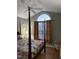 Bedroom with four-poster bed, arched window, ceiling fan, and warm lighting at 254 Pedernales Dr, Smithfield, NC 27577