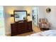 This bedroom features a wood dresser with a large mirror and a colorful sitting chair at 254 Pedernales Dr, Smithfield, NC 27577