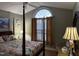 Bedroom with a four-poster bed, large arched window, and neutral decor at 254 Pedernales Dr, Smithfield, NC 27577