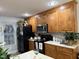 Bright kitchen featuring wooden cabinets, black appliances, and natural light from a window at 254 Pedernales Dr, Smithfield, NC 27577