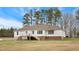 View of the home's exterior from the spacious backyard featuring a deck, white siding and red brick foundation at 2650 Spring Hill Rd, Spring Hope, NC 27882