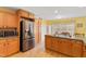Spacious kitchen features stainless steel appliances, wooden cabinets, and a dining area with natural light at 2650 Spring Hill Rd, Spring Hope, NC 27882