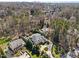 Aerial view of property with lush landscaping, circular driveway, and a pool in a wooded area at 2710 Cambridge Rd, Raleigh, NC 27608