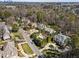 Wide aerial shot showcasing neighborhood homes with mature trees, lawns, and a winding street at 2710 Cambridge Rd, Raleigh, NC 27608