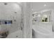 Contemporary bathroom featuring a glass-enclosed shower with marble tile, soaking tub, and a spacious vanity at 2710 Cambridge Rd, Raleigh, NC 27608
