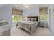 Well-lit bedroom with windows, neutral decor, and plush carpet at 2710 Cambridge Rd, Raleigh, NC 27608