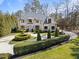 Breathtaking white brick home with elegant landscaping, circular driveway, and mature trees at 2710 Cambridge Rd, Raleigh, NC 27608