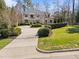 Desirable white brick home with circular driveway, mature trees, and professionally landscaped lawn at 2710 Cambridge Rd, Raleigh, NC 27608